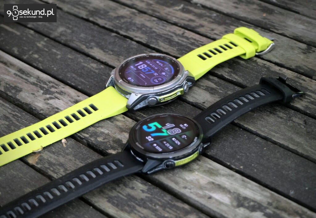 Na zdjęciu smartwatch Garmin Fenix 8 51 mm z ekranem MIP w wersji Solar Sapphire, a obok Garmin Forerunner 970 - 90sekund.pl